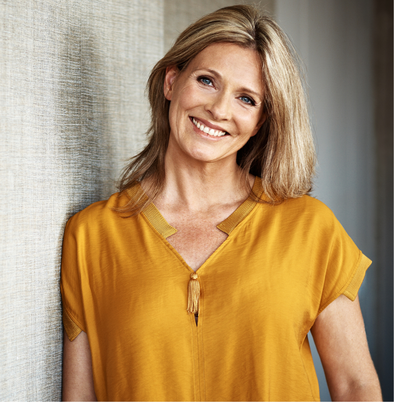 Smiling middle aged woman in yellow shirt