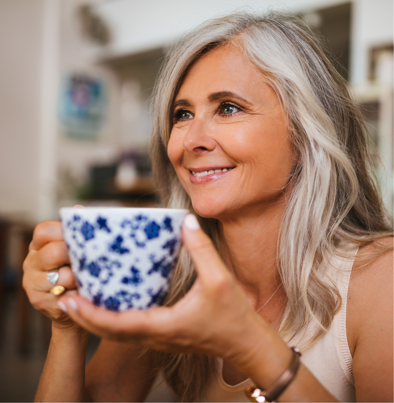 smiling older woman holding tea cup