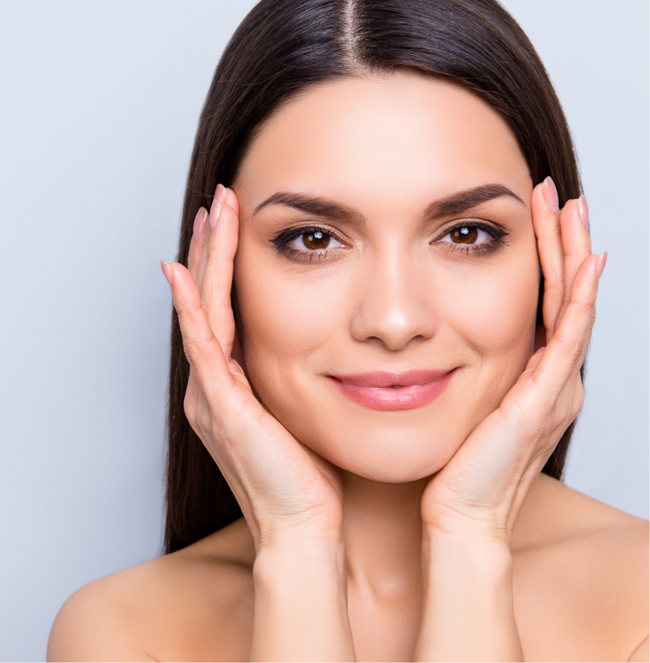 Model smiling with hands on her face