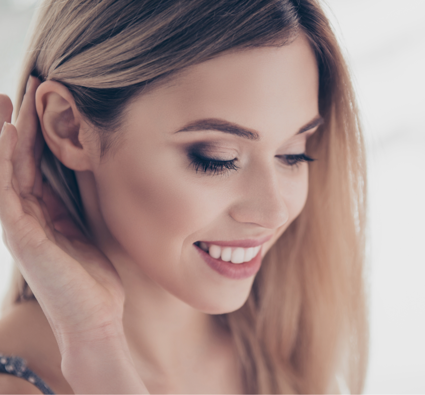 smiling woman ticking hair behind her ear