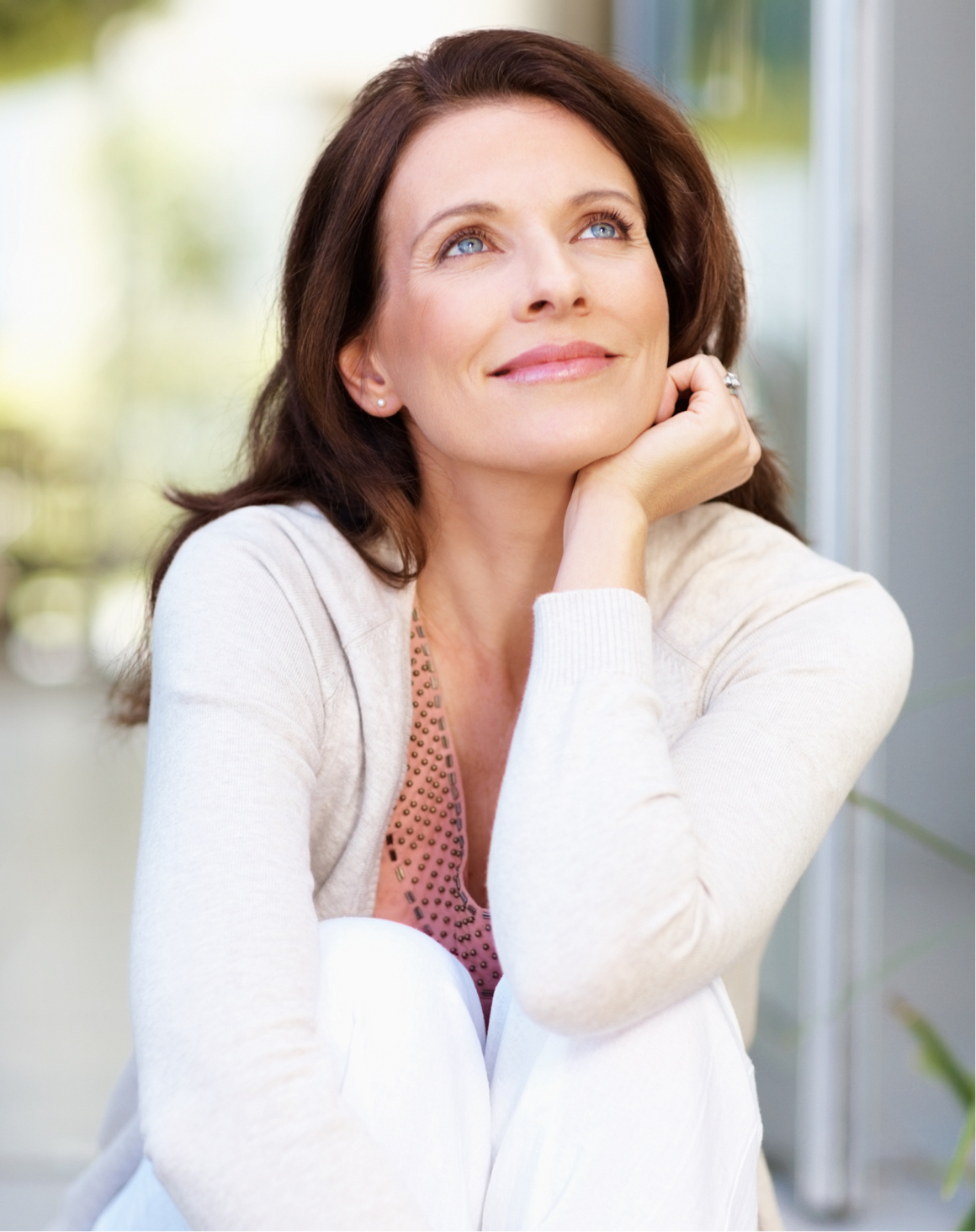 Brunette model smiling with hand on chin